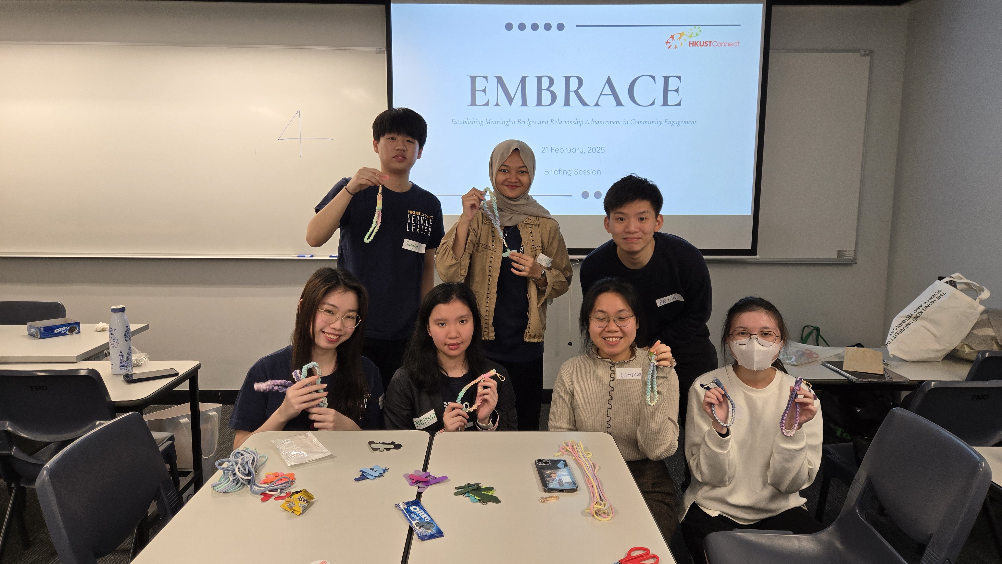 Volunteers learning how to make phone straps for service