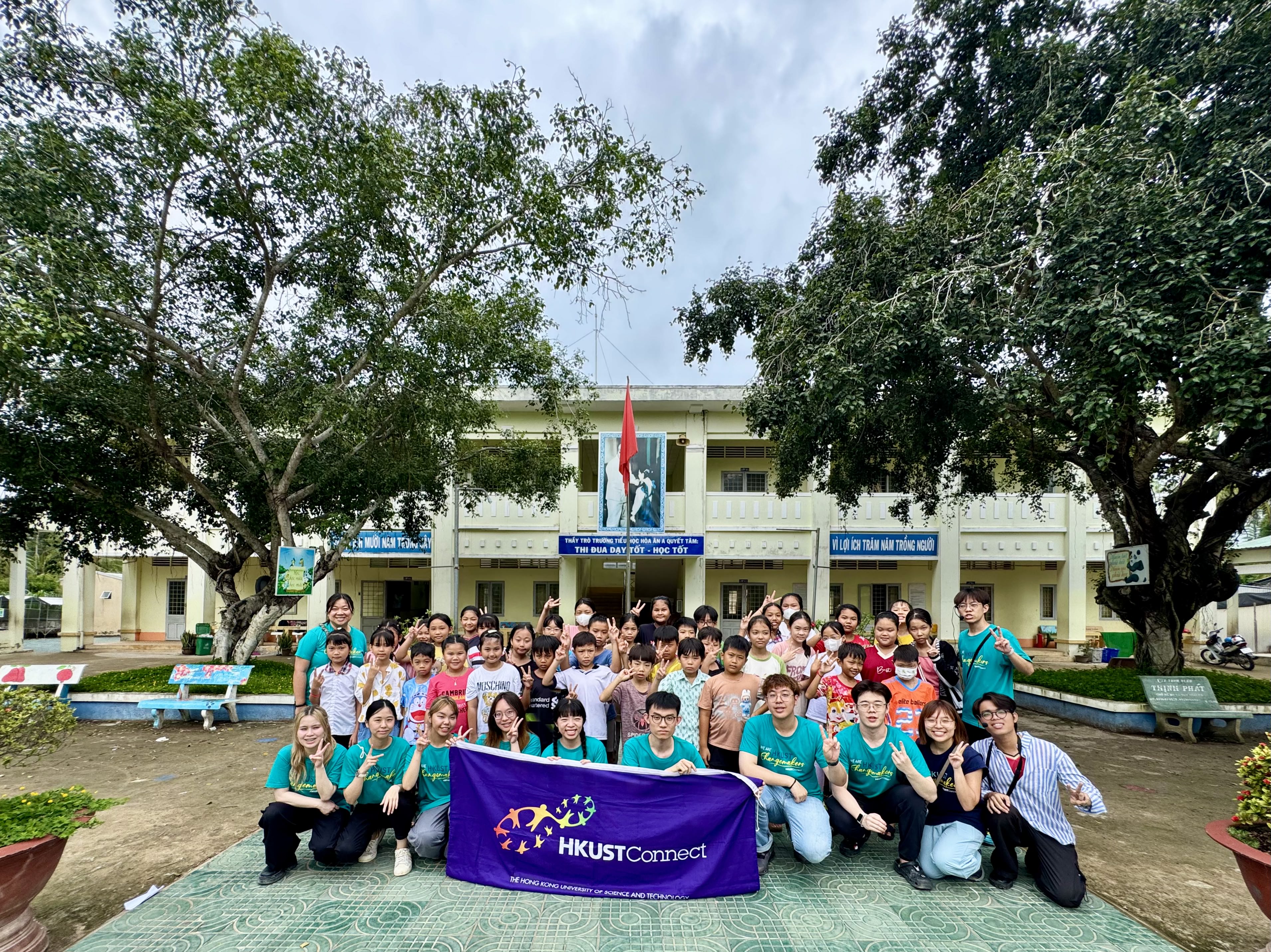 Volunteers and local children gathering for a group photo after completing the teaching
