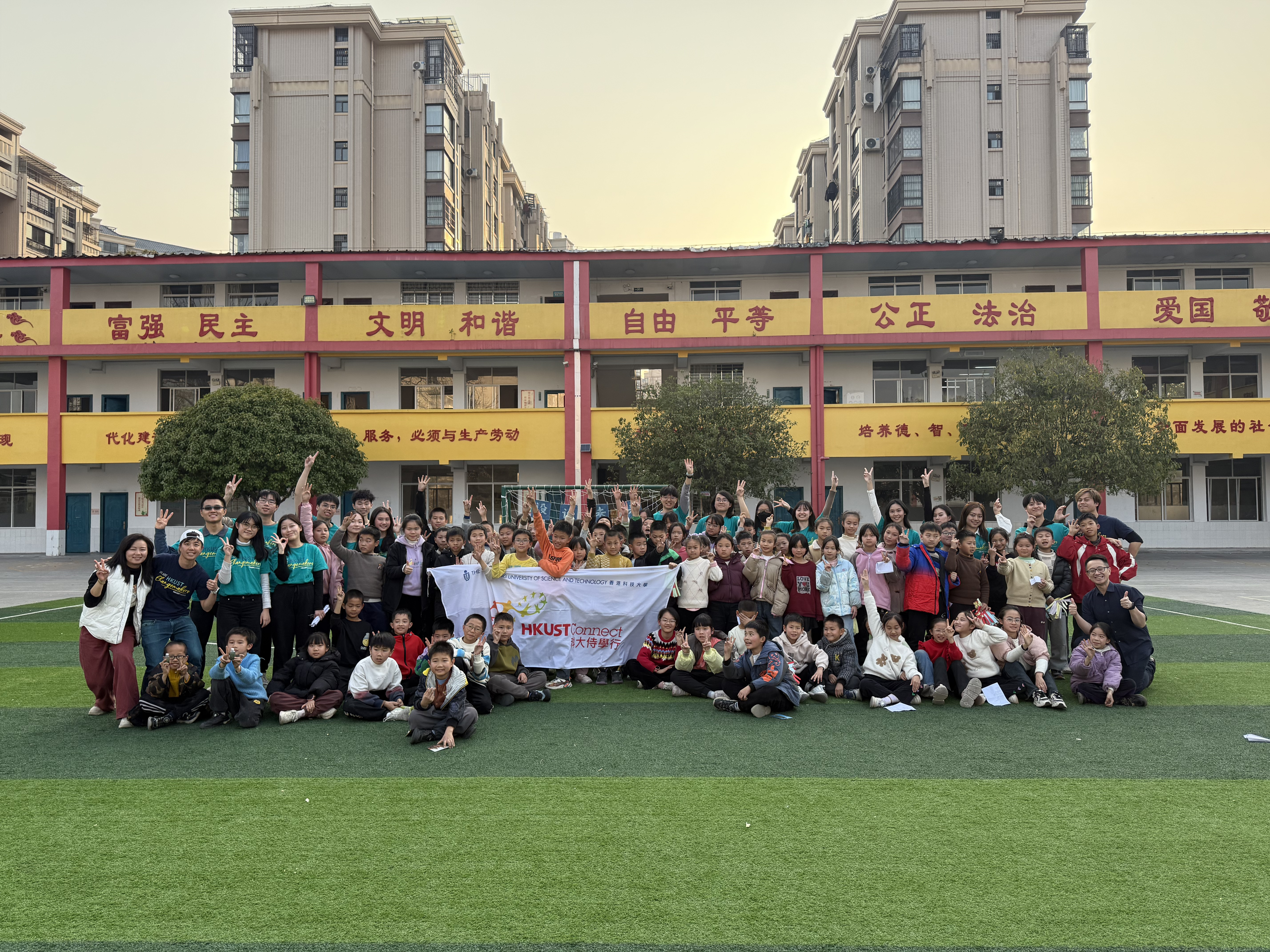 students and volunteers in front of the school building
