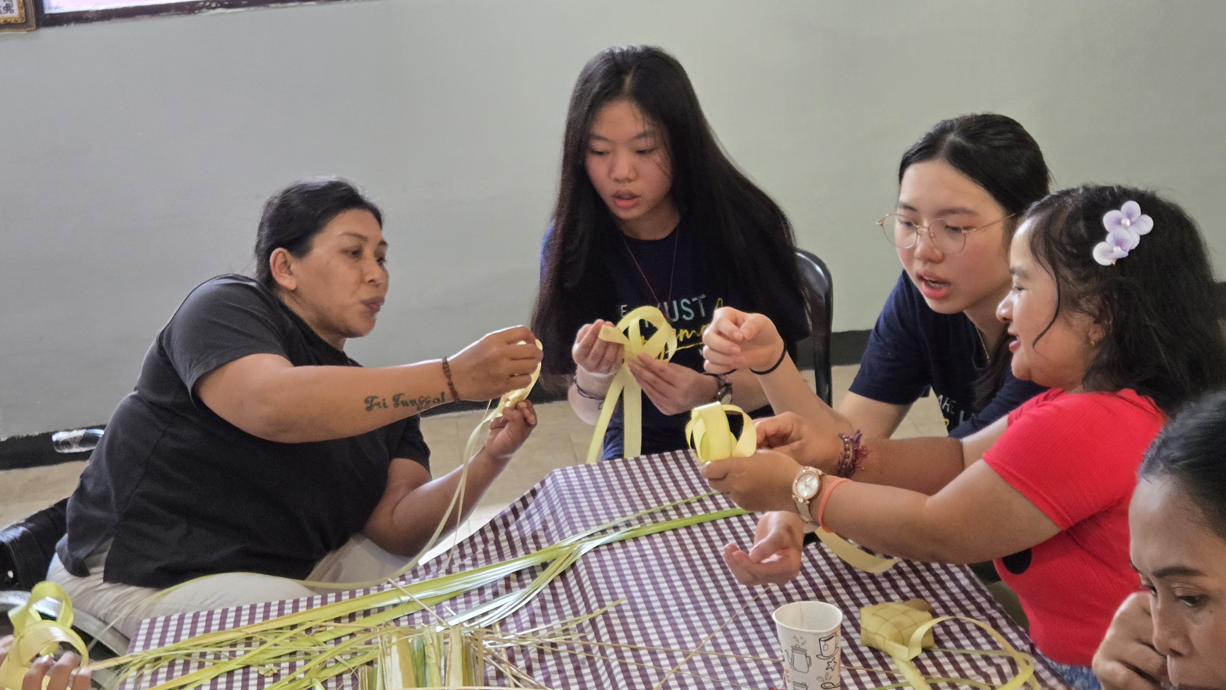 Volunteers learning from Cahaya Mutiara members on how to make traditional local handicrafts 