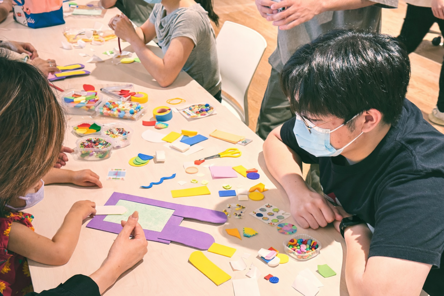 Volunteers and children co-creating photo frames