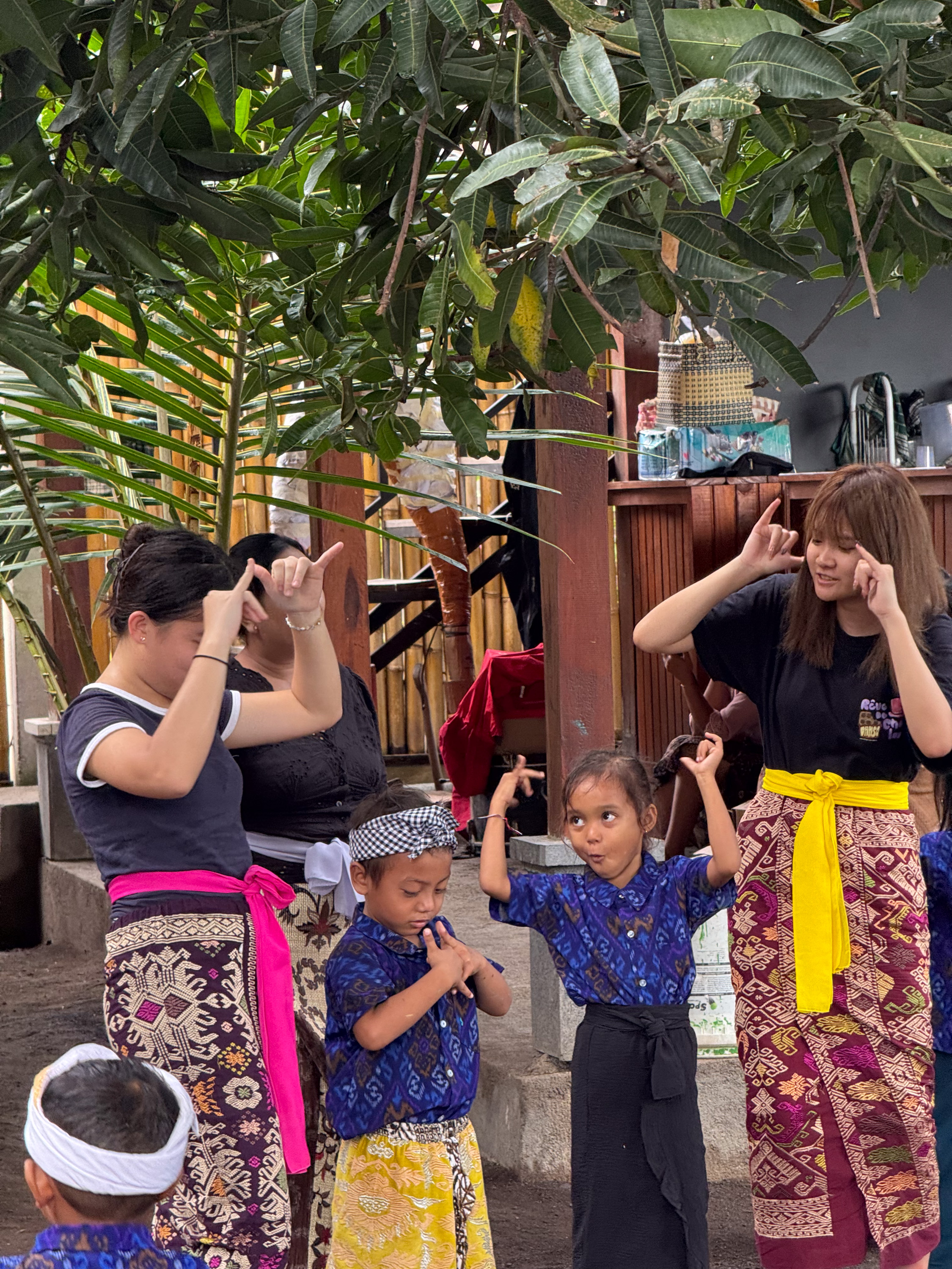 Volunteers teaching kindergarten students English through singing and dancing.