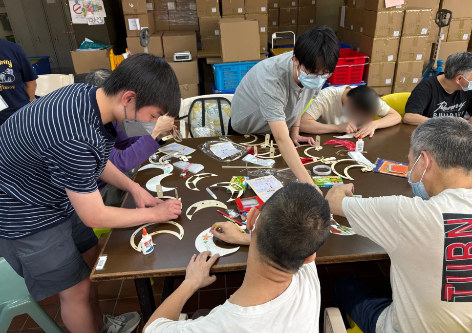 Volunteers and hostel residents crafting a Mid-Autumn lantern