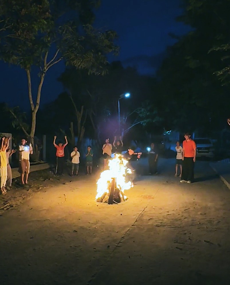 Local children and volunteers celebrating around a campfire on their last night in Tra Vinh