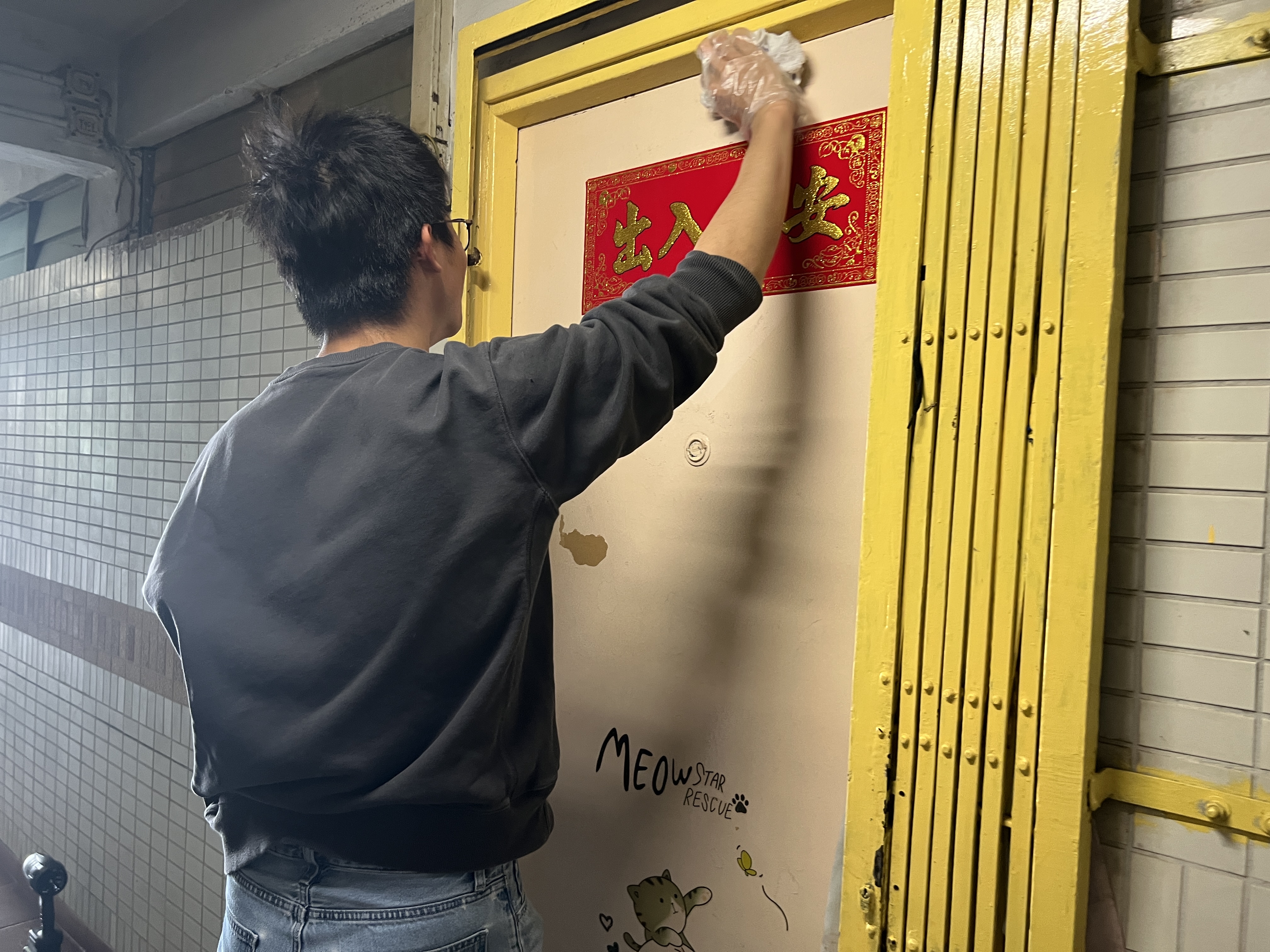 Volunteer cleaning the front gate for an elderly resident