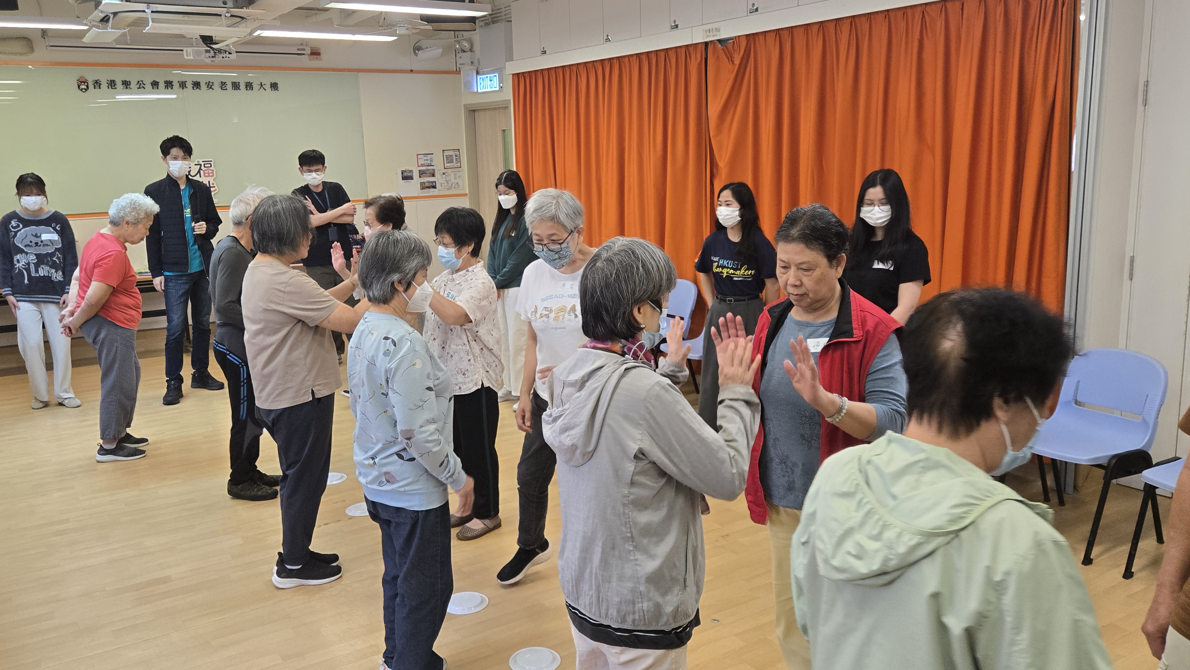 Volunteers assisting elderly participants in game-based exercise