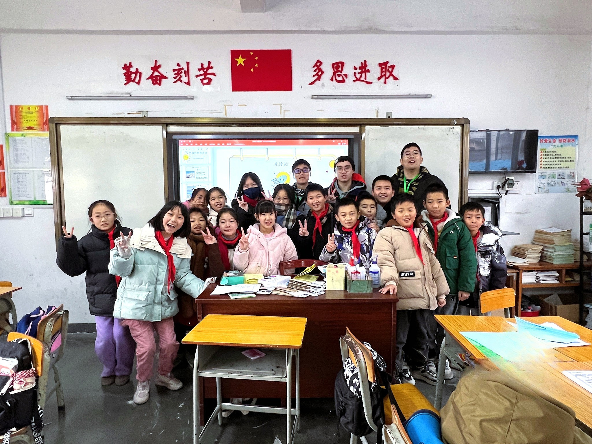 A classroom of smiles with volunteers and children.