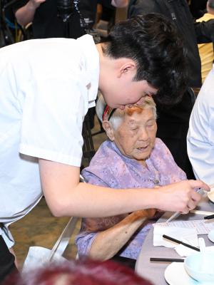 volunteer chatting with an elderly in a soft meal service