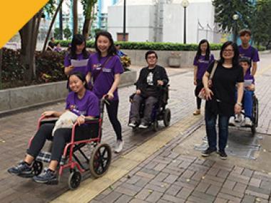 Volunteers experiencing wheelchair challenge.