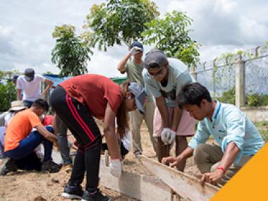 Volunteers building the concrete base together with the the local children.