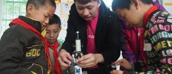 volunteers teaching mainland kids to use microscope
