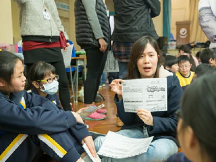 Volunteer explaining concepts of money management to the students
