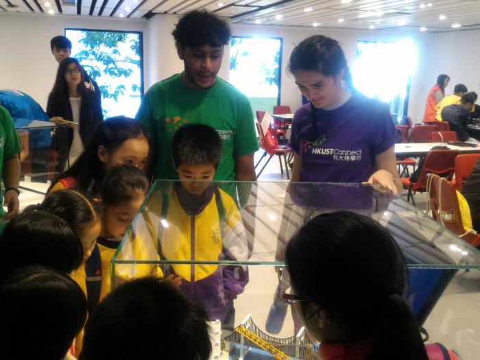 Children fascinated by the engineering model displayed on campus
