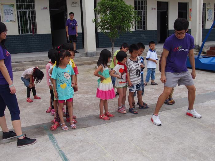 A volunteer leading the children in a sports activity