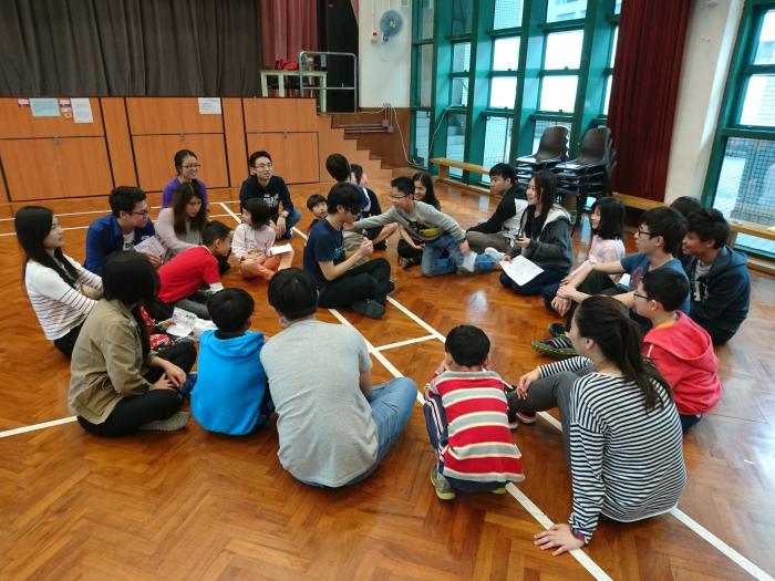 Volunteers and the children forming a circle and playing a group game together