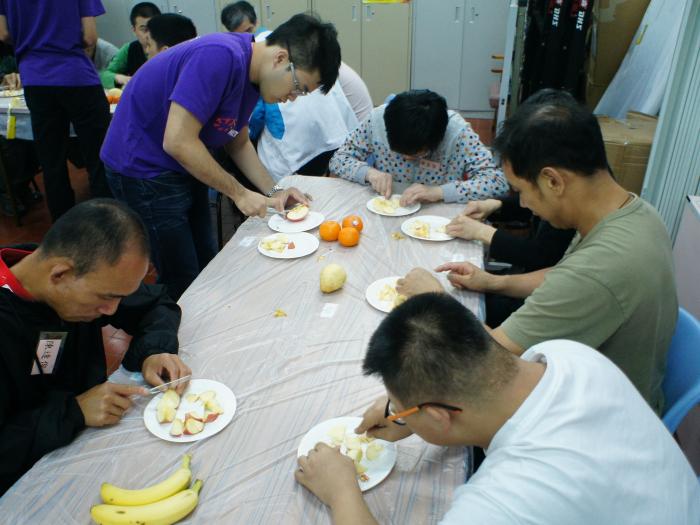 Volunteers teaching the service recipients to prepare simple fruit salad and sandwiches