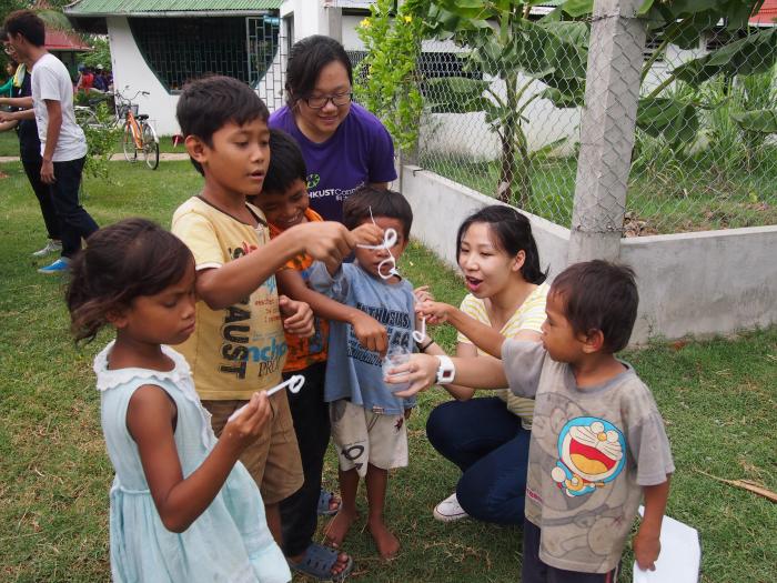 Volunteers blowing bubbles with children 