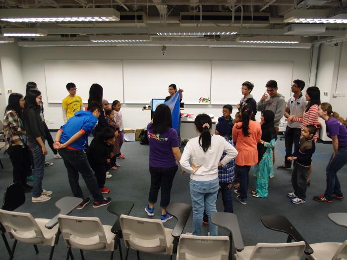 Children following the body movement of the volunteers in a game