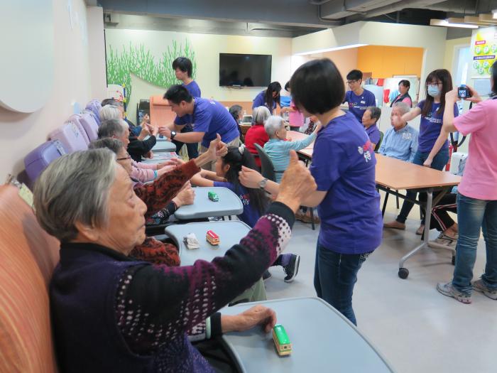 Volunteers helping the elderly doing exercise with their hands and eyes