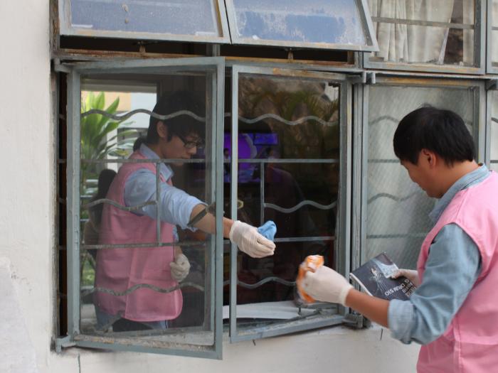 Volunteers cleaning the windows of the service recipients