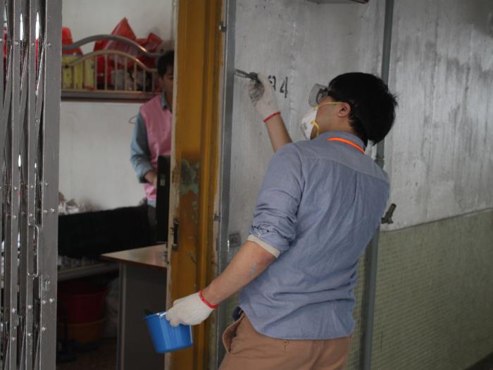 Volunteer painting the wall of the elder's home