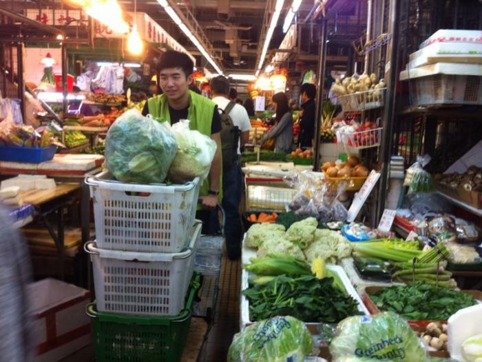 Volunteer collecting the vegetables in the wet market