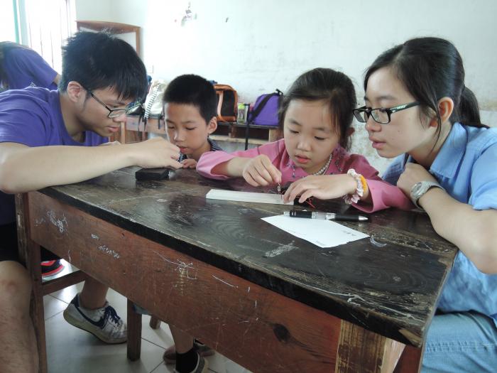 Volunteers teaching children to make a complete circuit