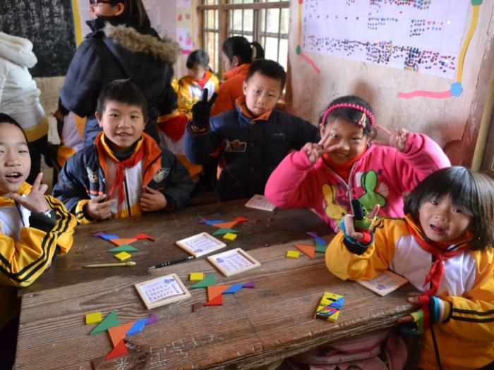 Children playing with tangram puzzles to strengthen their cognitive skills  