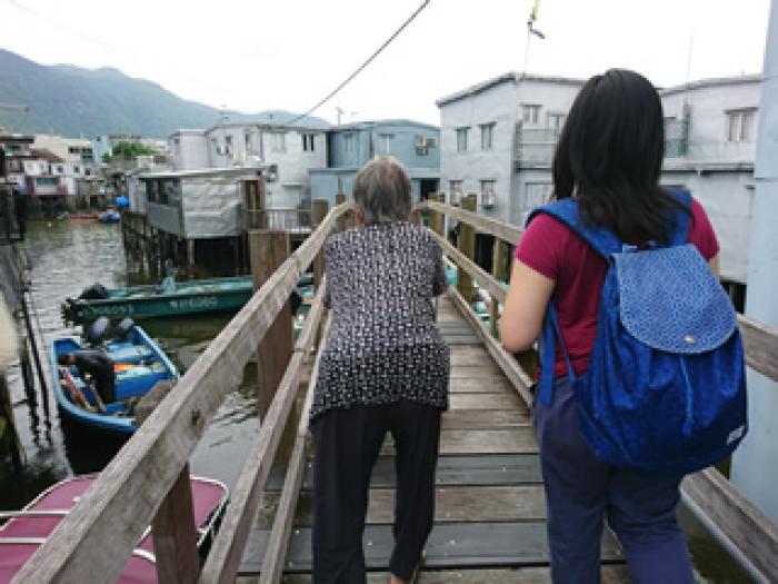 Volunteer and the elderly on their way back to the stilt house