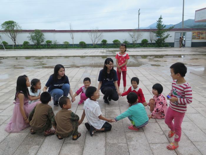 Volunteers and children in the village playing games together in the playground