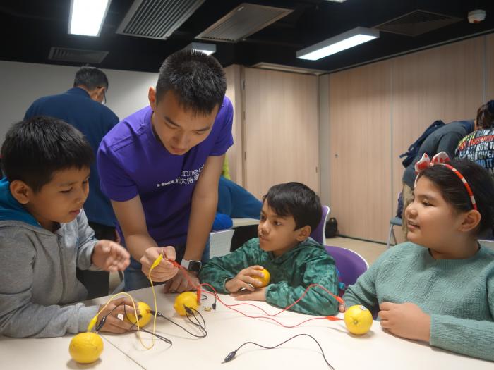 Volunteer guiding the kids to do an interesting experiment