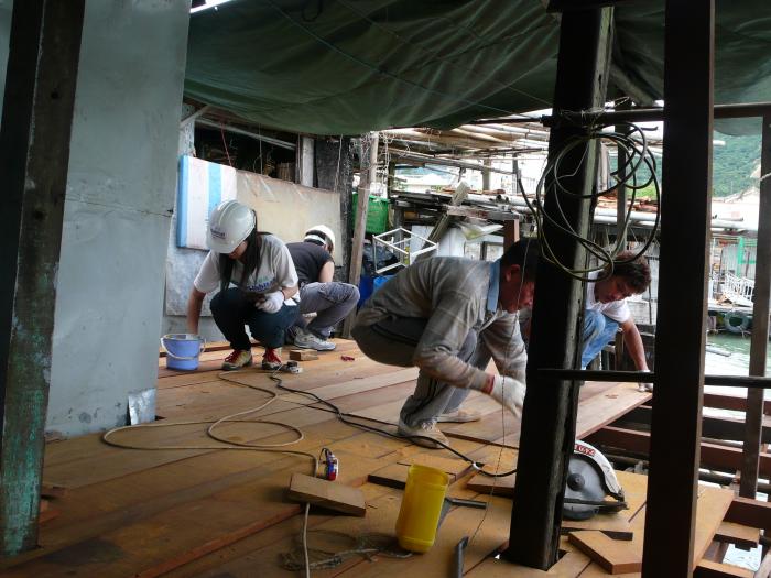 Students working with local workers to restore the floor.