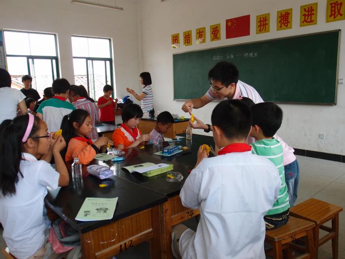 Student explaining science concepts to children through simple experiments