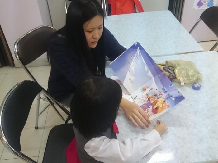 Volunteers reading story books with a child