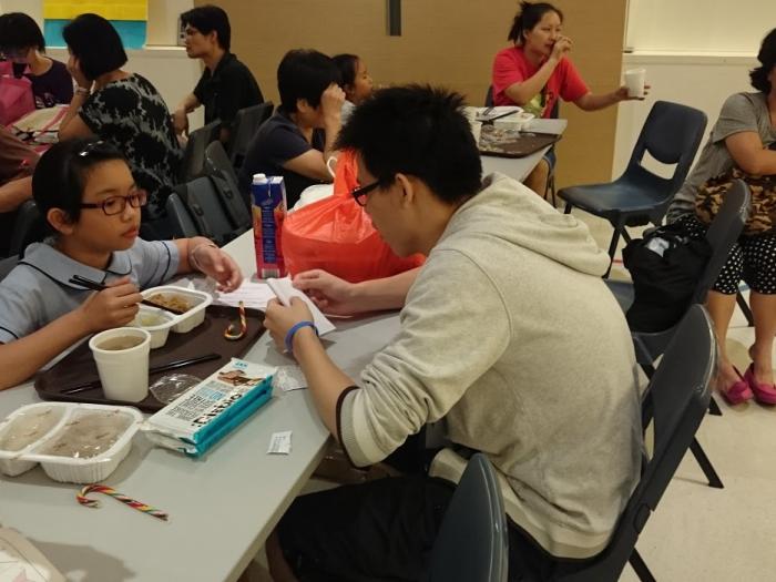 Volunteer chatting with the children during dinner