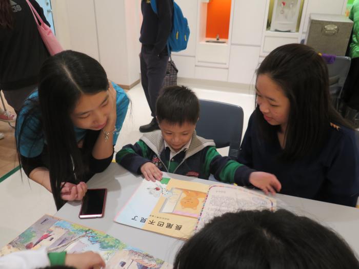 Volunteers reading books with the children
