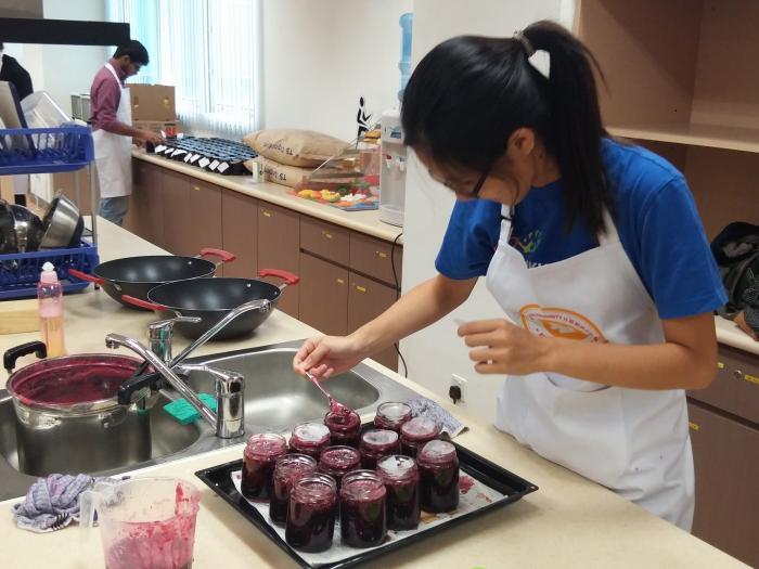Carefully filling jars with fresh jam!
