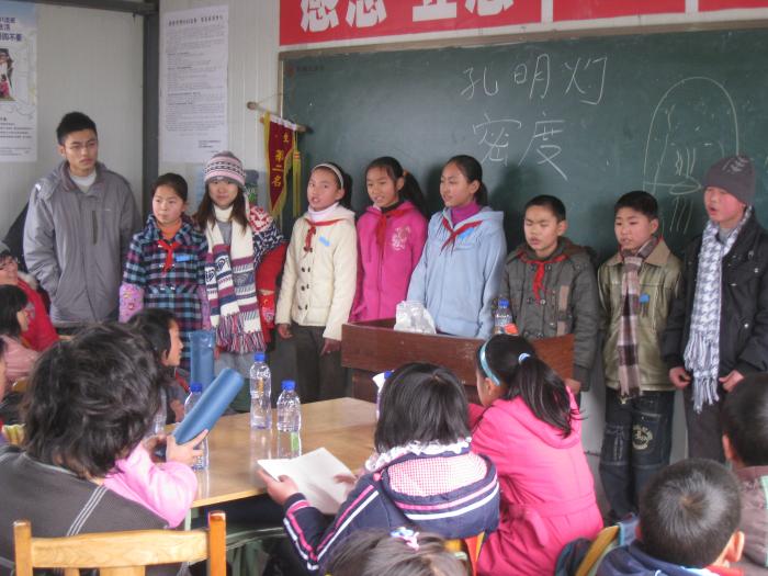 Children singing songs to thank you out student colunteers for their teaching.