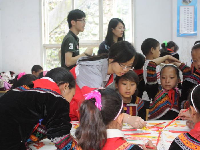 Volunteers helping children to design their own bags