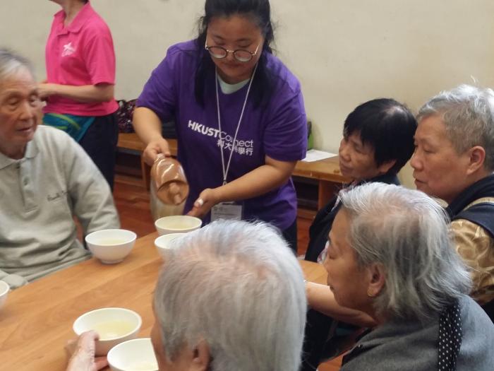 A volunteer distributing chinese soup to the elderly.