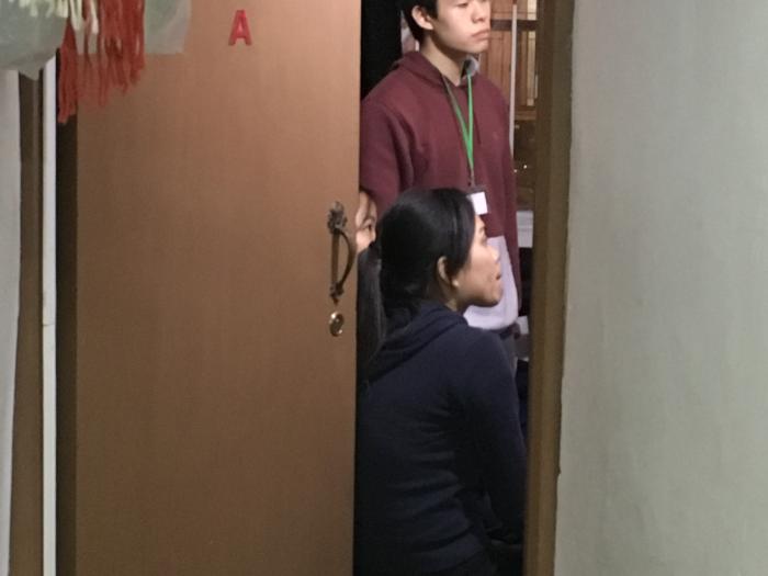 Volunteers visiting a family living in a subdivided housing unit