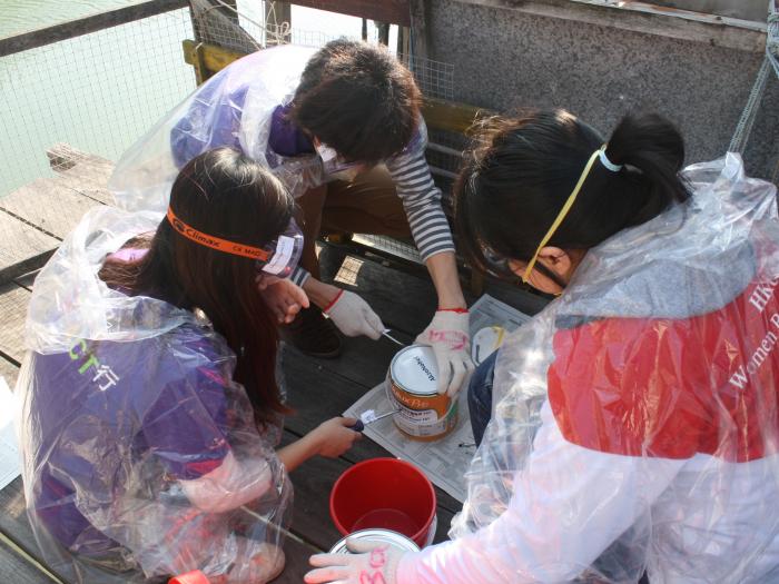 Volunteers preparing the paint for refurbishment