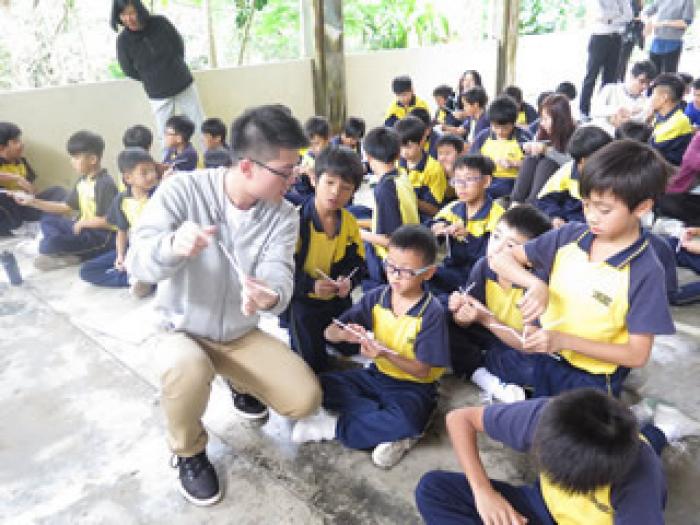 Volunteer teaching the children magic skills