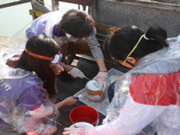 Volunteers preparing the paint for refurbishment