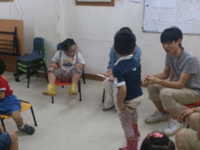 Volunteers playing games happily with the kids