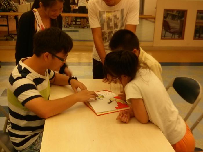 Children and volunteers reading English story books together