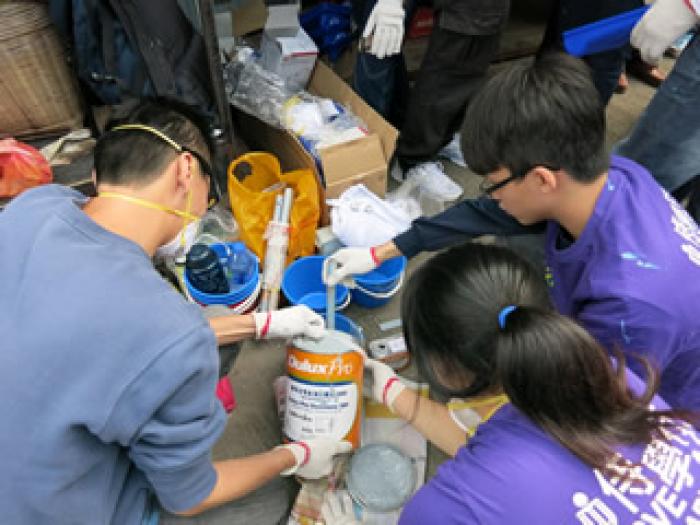 Volunteers preparing the paint for refurbishment