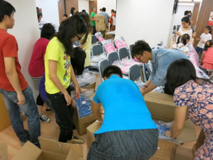 Volunteers distributing school bags to children
