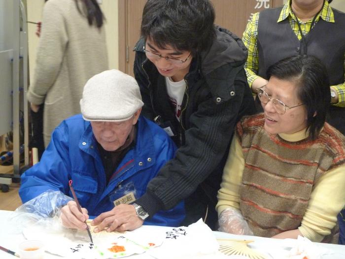 Elders writing their own messages on the paper fans.