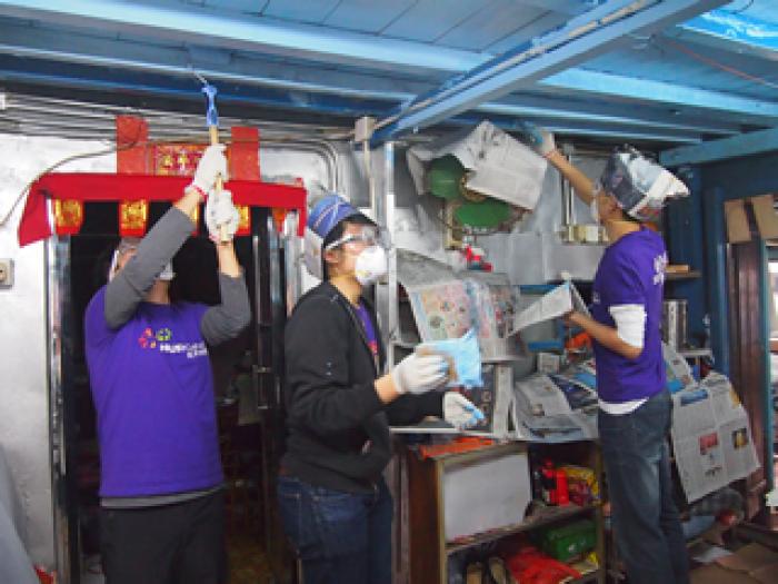 Volunteers painting the interior of a stilt house